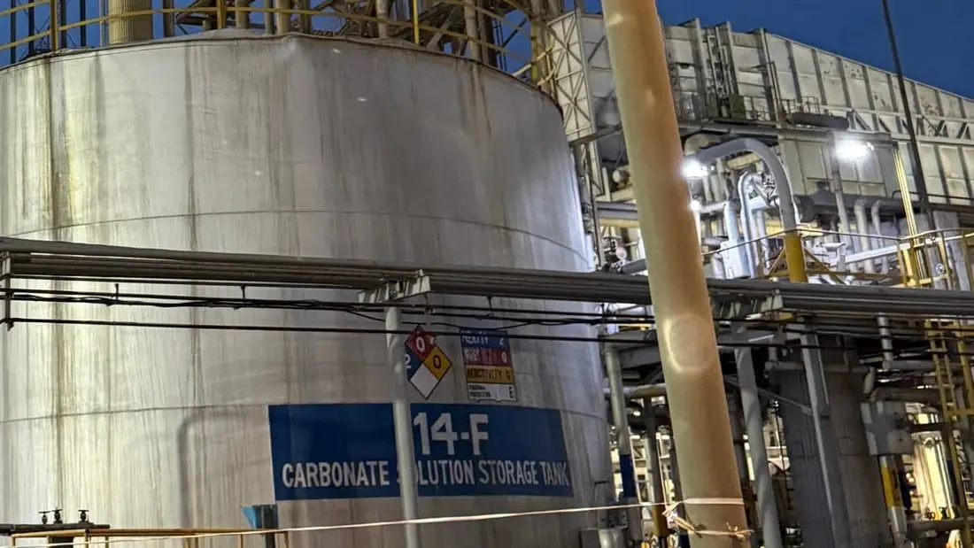 A carbonate solution storage tank in a fertilizer plant at dusk